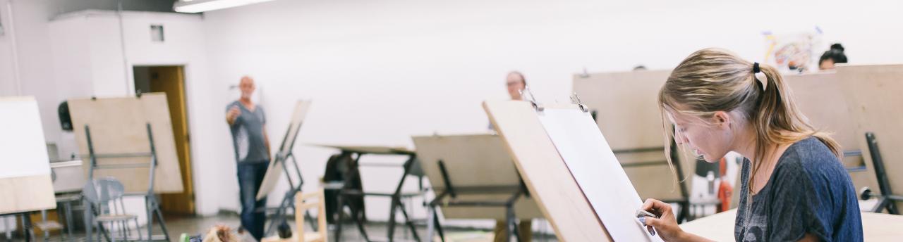class of students paints on easels.