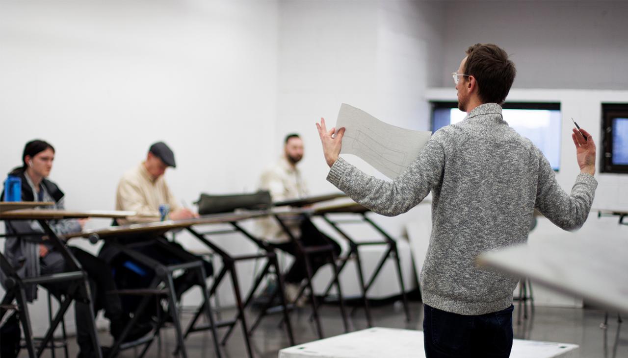 continuing education instructor teaching drawing course to a class in a studio