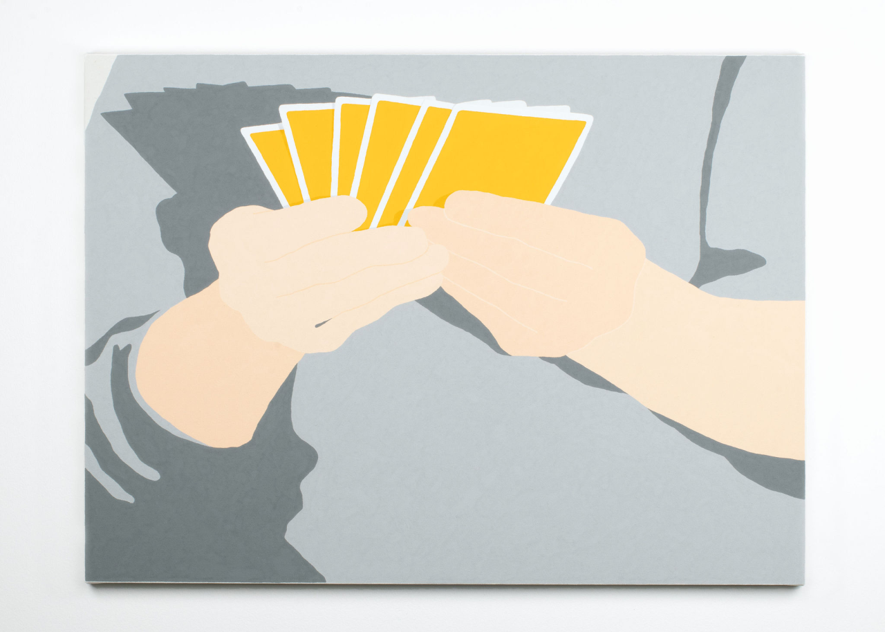 A close-up painting of a pair of hands holding yellow playing cards. The hands belong to a person wearing a gray sweater, and the artwork maintains a simple, graphic style.