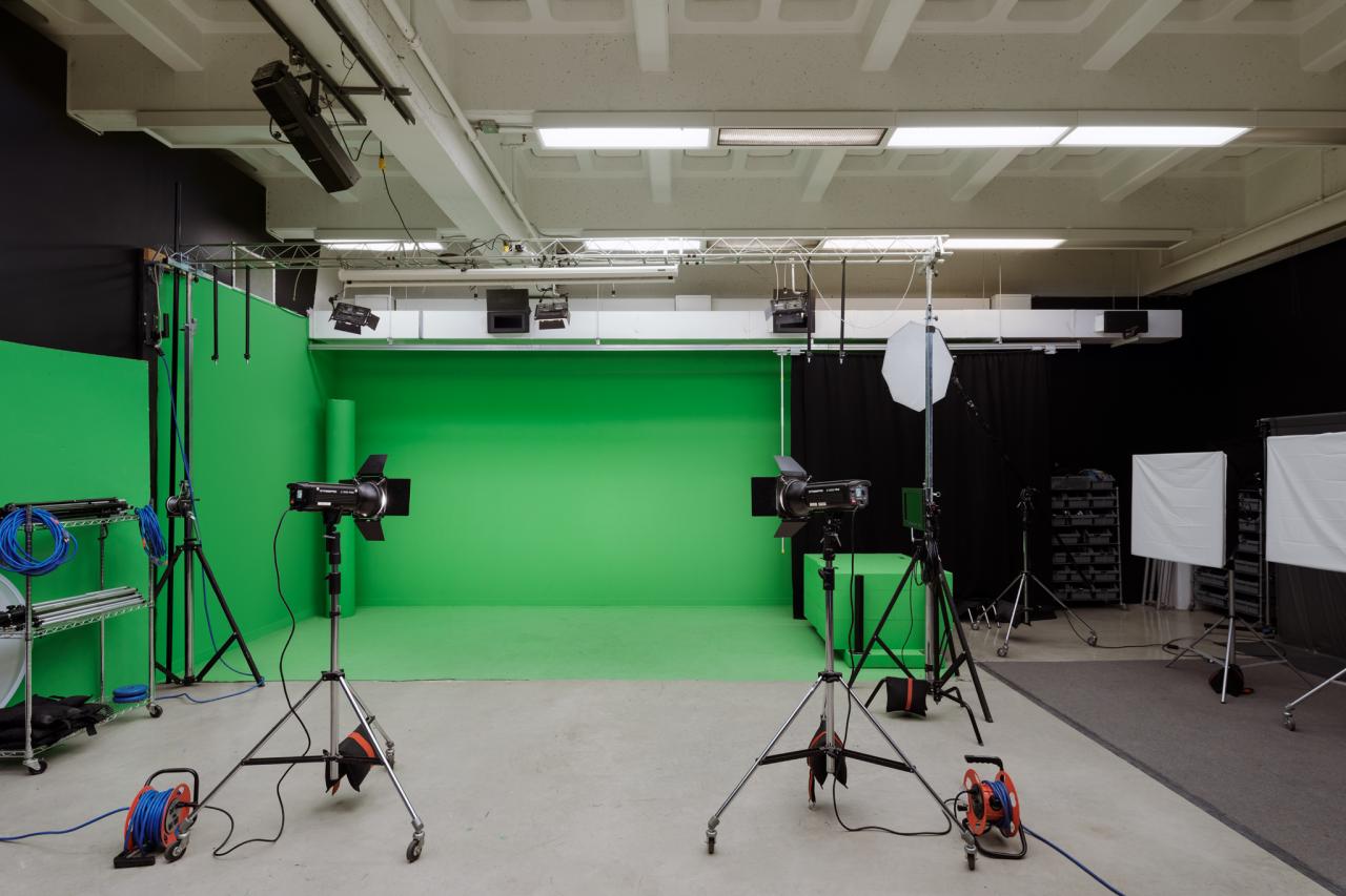 Media Studio AUArts media studio with green screen backdrop, studio lighting, cables, and photography equipment.