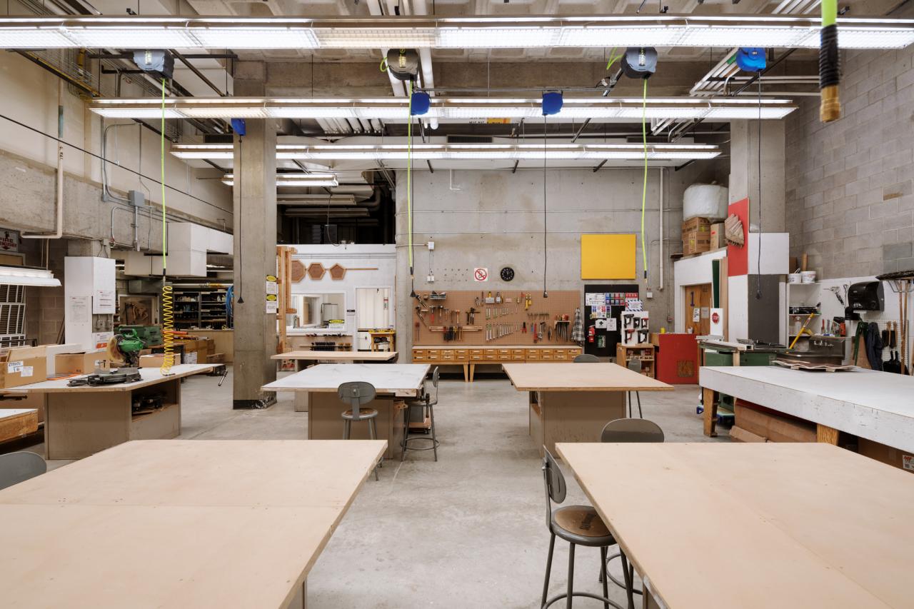 Wood Shop 1 AUArts wood shop with large workbenches, hanging power cords, and tool stations organized along the back wall.