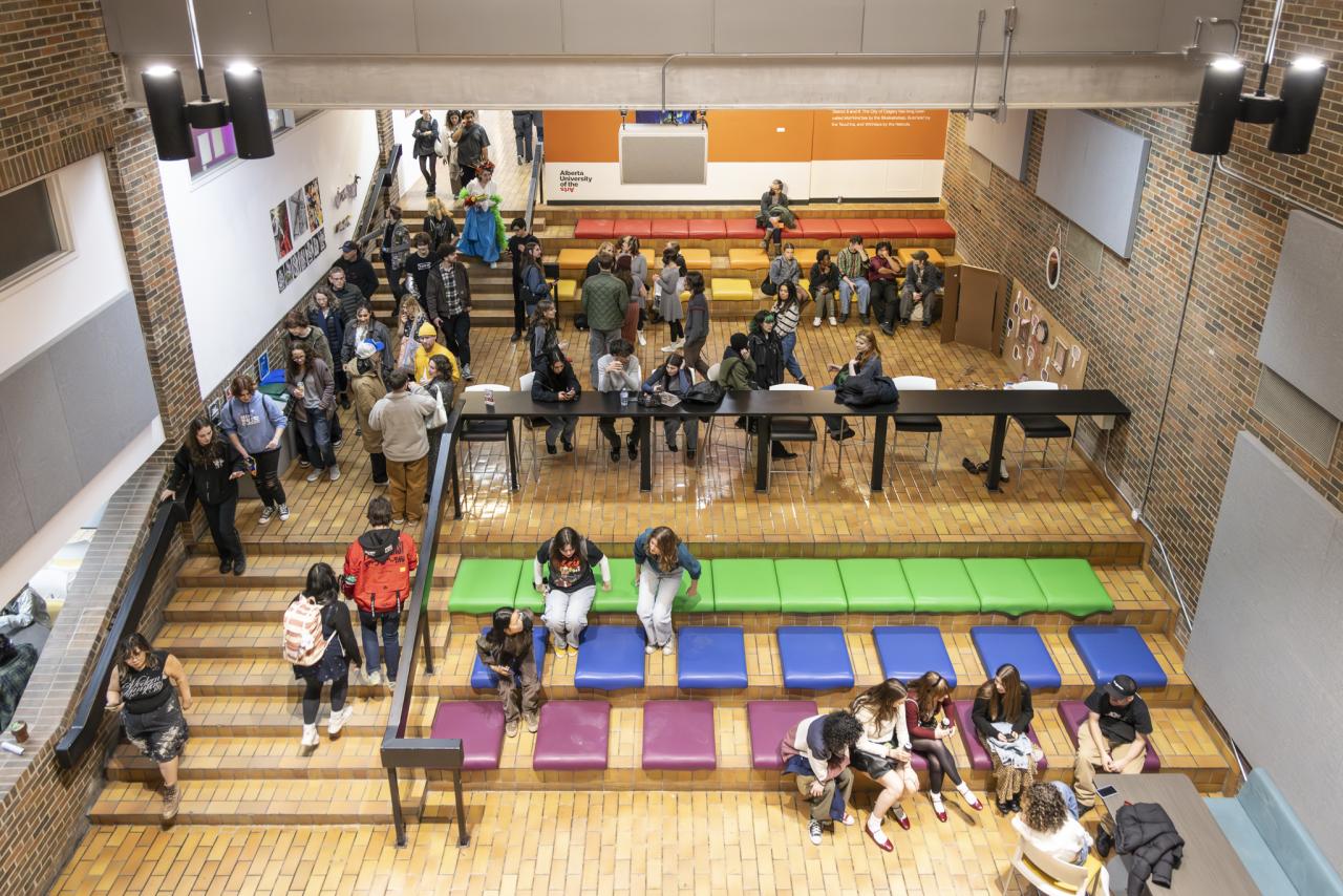 Overhead view of students gathering, studying and socializing in a tiered brick seating area inside AUArts.