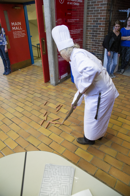 The artist is herding hot dogs in the institution. 
