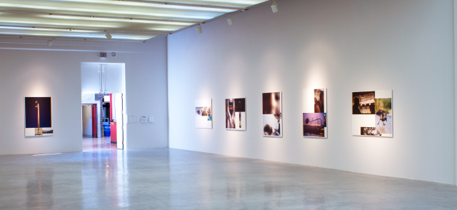 Wide shot of the gallery. We can see the doors to exit. There are six hanging bamboo prints we can see. 