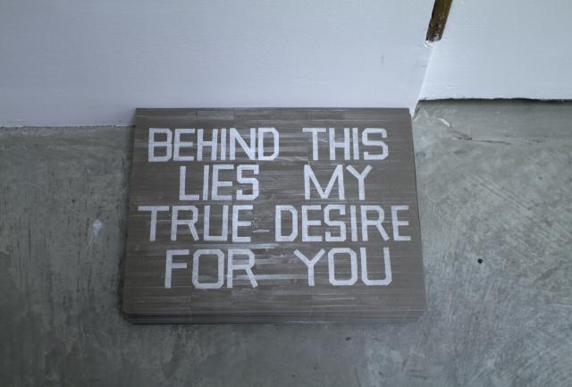 Detail of the block of wood with the same text as the wall.