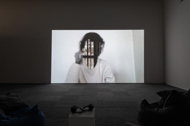 The Beyond Within video being shown in a darkened gallery with headphones and bean bag chairs