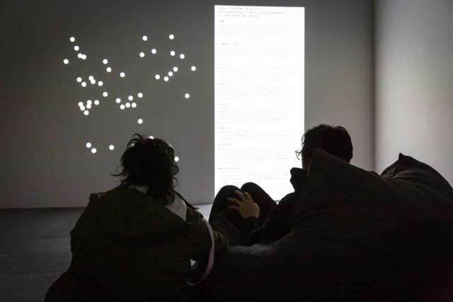 People watching a video installation from The Beyond Within while reclining in bean bag chairs