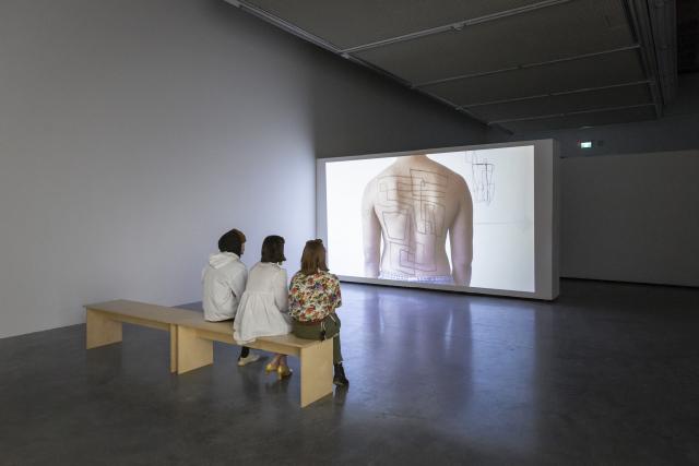 Three people watching part of Communicating Vessels from The Beyond Within