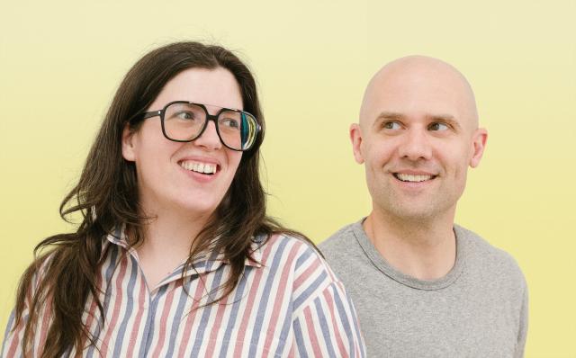 Morgan Curley and Marc Husted of Public Eye smiling against a yellow background