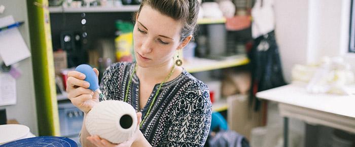 woman painting ceramic