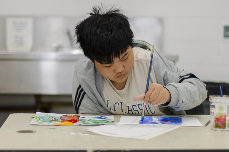 Painting party kids camps student paints a picture at their desk