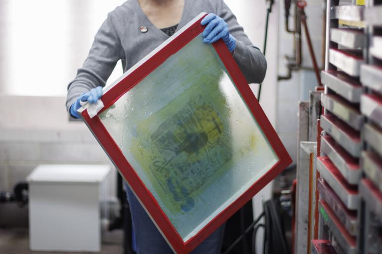 silk screening on fabric personal interest student wipes a mesh screen printing frame.